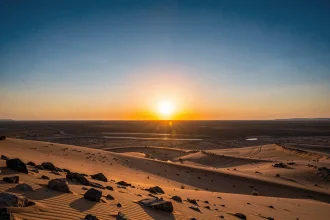 Lever de soleil à l'est sur un paysage désertique, horizon dégagé illustrant la direction du soleil levant