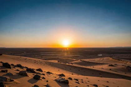 Lever de soleil à l'est sur un paysage désertique, horizon dégagé illustrant la direction du soleil levant